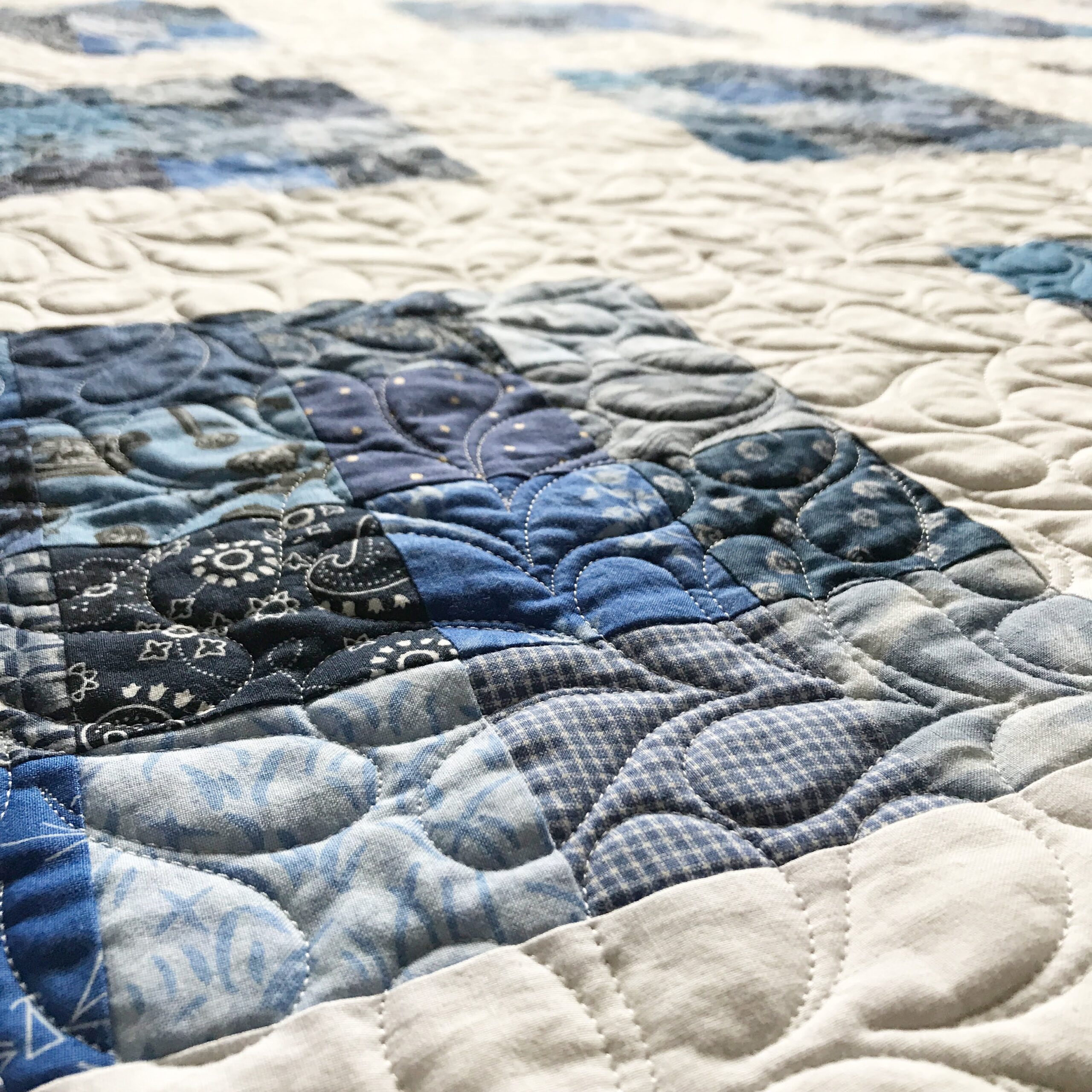 All over feathers on a blue and white quilt